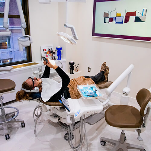 A patient of Dr. Husam lying in the dentist's chair while listening to music